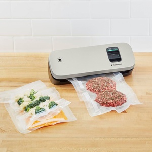 aparat de vidat foodsaver vs1190x alb pe masa cu mancare in vid